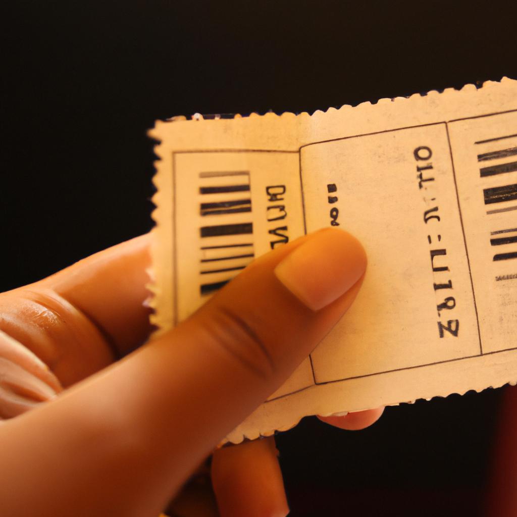 Person holding movie ticket stub